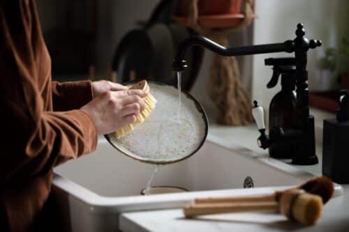 Woman washing dishes with brush
