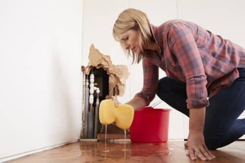 woman cleaning up after finding hidden water leak
