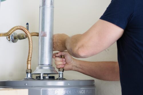 professional plumber performing water heater repair